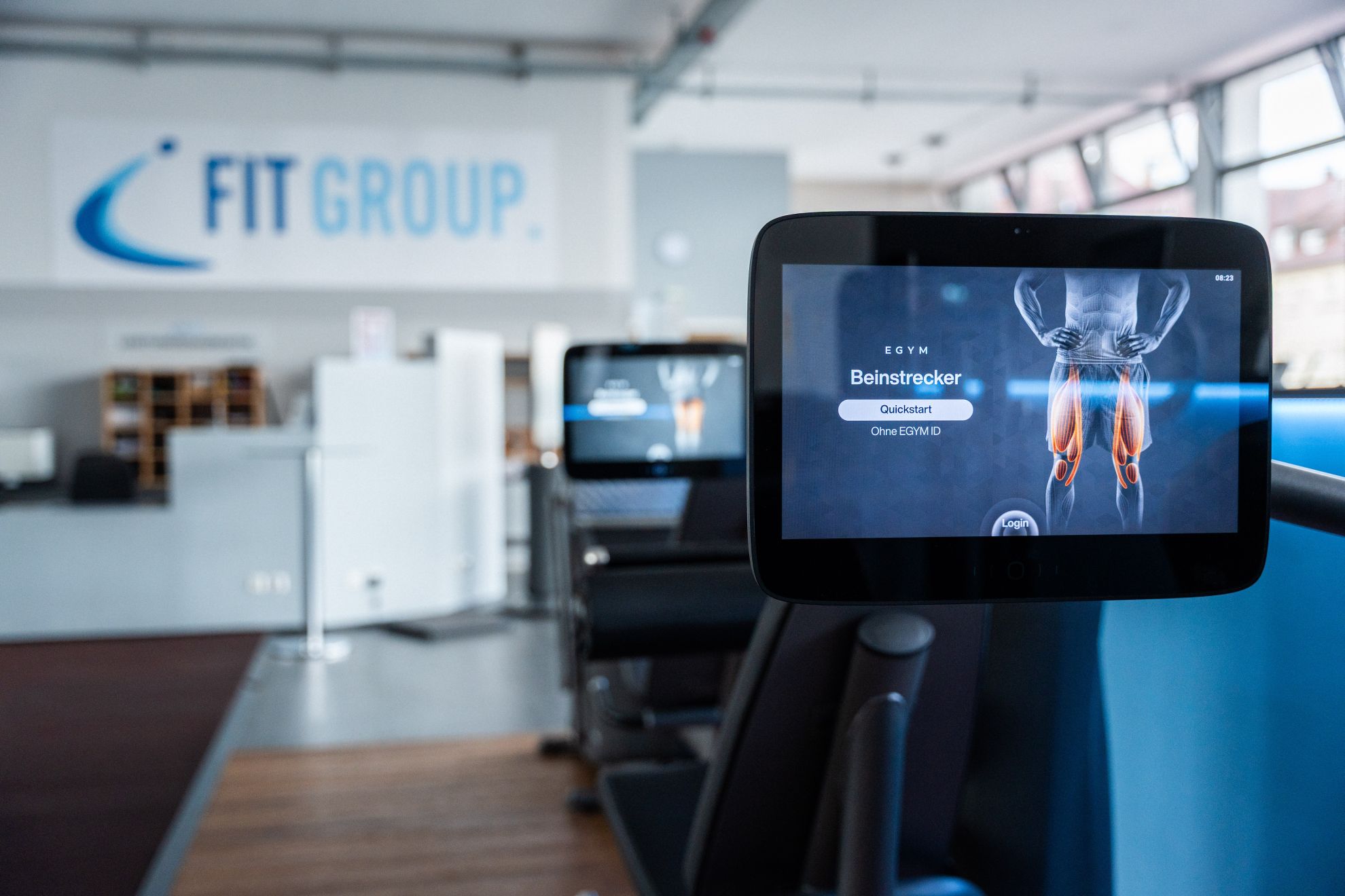 EGYM-Gerät mit Display vor dem FITGROUP-Logo in Ulm
